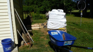 Future antenna site with concrete mixer, pallet of concrete, and wheel barrow.