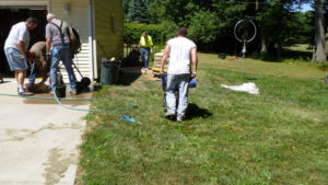 Thad Foster pushing wheel barrow of concrete to antenna base location.